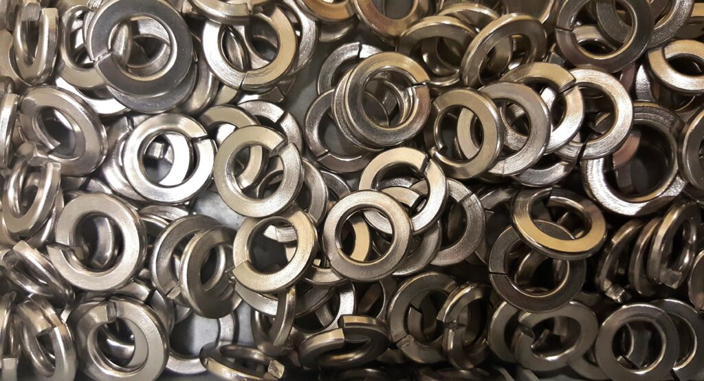 Metal washers and nuts on a steel surface